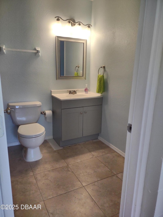 bathroom featuring tile patterned floors, toilet, vanity, and baseboards