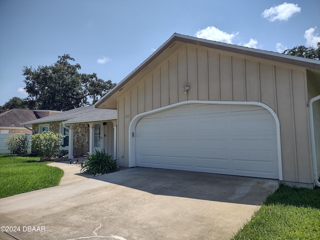 view of front facade featuring concrete driveway, a garage, and board and batten siding