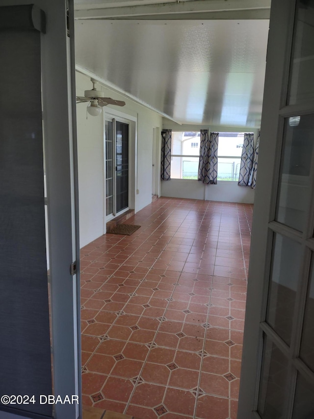 unfurnished sunroom featuring ceiling fan