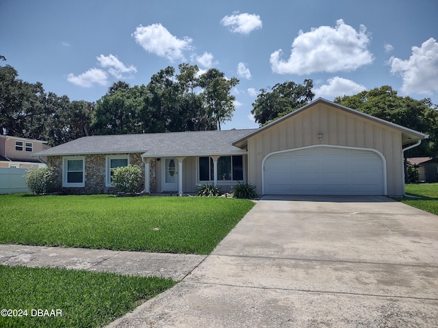 ranch-style home featuring a front yard, fence, driveway, an attached garage, and a shingled roof