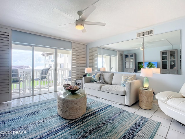 living room with a textured ceiling, a healthy amount of sunlight, ceiling fan, and light tile patterned flooring