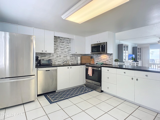 kitchen featuring stainless steel appliances, white cabinets, sink, and decorative backsplash