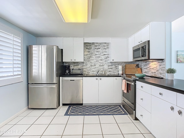 kitchen with white cabinetry, appliances with stainless steel finishes, sink, and backsplash