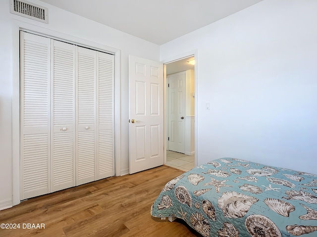 bedroom with wood-type flooring and a closet