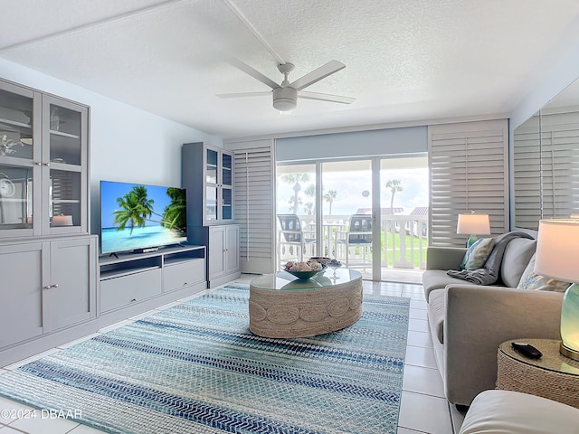 tiled living room with a textured ceiling and ceiling fan