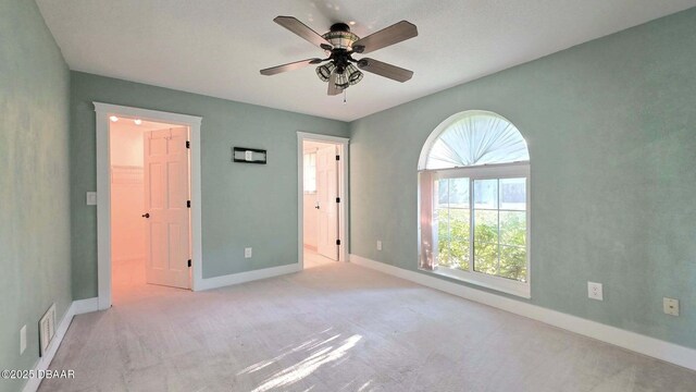 3128 John Anderson Dr, Ormond Beach, FL 32176 - unfurnished bedroom with a walk in closet, carpet flooring, and a ceiling fan