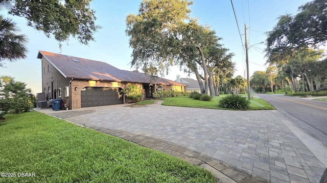 3128 John Anderson Dr, Ormond Beach, FL 32176 - view of side of property featuring a garage, a yard, decorative driveway, and brick siding