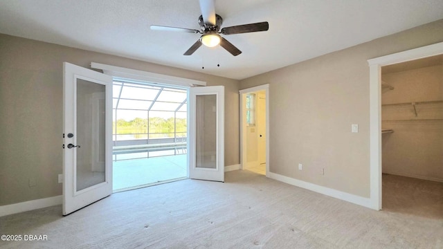 3128 John Anderson Dr, Ormond Beach, FL 32176 - unfurnished bedroom featuring french doors, access to outside, carpet, a walk in closet, and ceiling fan