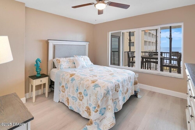 bedroom featuring ceiling fan, a water view, and light hardwood / wood-style floors