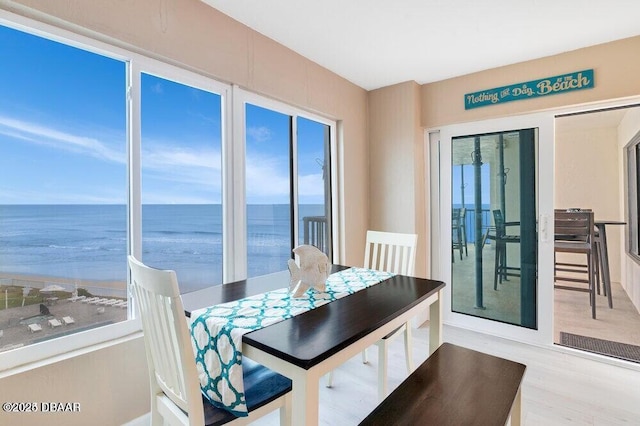 dining room featuring a water view and light hardwood / wood-style floors