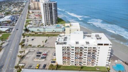 birds eye view of property with a water view and a view of the beach