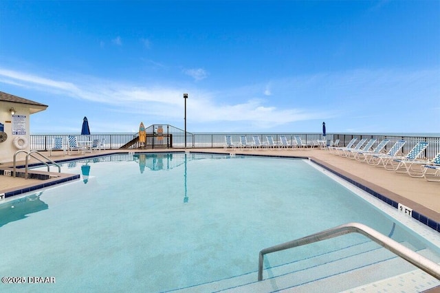 view of swimming pool with a water view and a playground