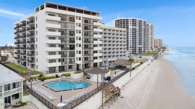 view of building exterior with a beach view and a water view