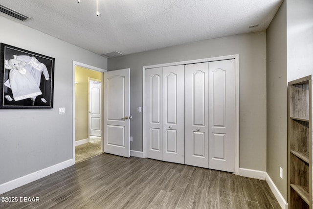 7 Foxfords Chase, Ormond Beach, FL 32174 - unfurnished bedroom with wood finished floors, a textured ceiling, and a closet