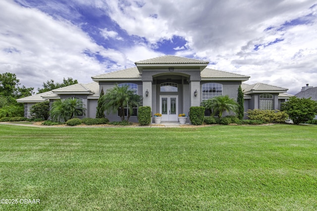 7 Foxfords Chase, Ormond Beach, FL 32174 - mediterranean / spanish house with french doors, stucco siding, a tiled roof, and a front yard