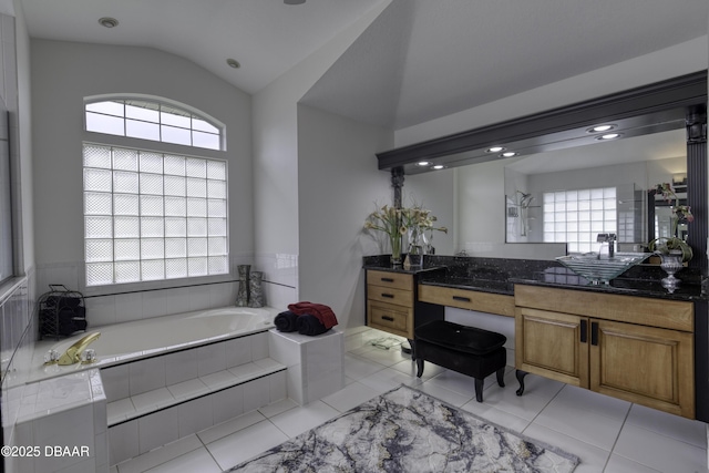 7 Foxfords Chase, Ormond Beach, FL 32174 - bathroom featuring healthy amount of natural light, vanity, a garden tub, vaulted ceiling, and tile patterned floors