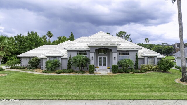 7 Foxfords Chase, Ormond Beach, FL 32174 - mediterranean / spanish house featuring french doors, stucco siding, a front lawn, and a tile roof