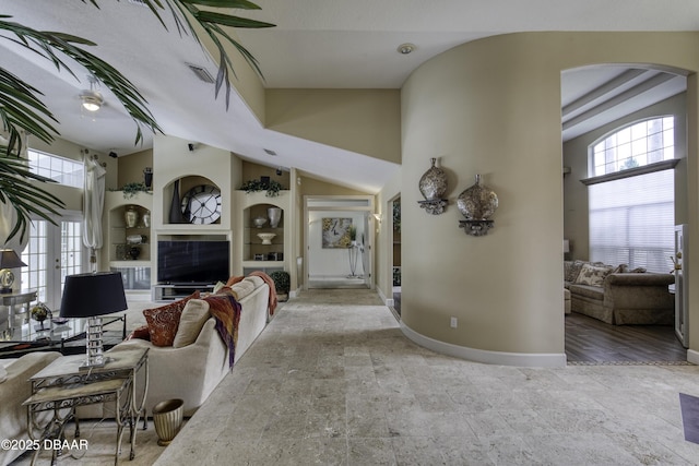 7 Foxfords Chase, Ormond Beach, FL 32174 - living area featuring plenty of natural light, arched walkways, built in shelves, and a high ceiling