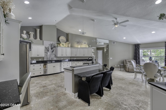 7 Foxfords Chase, Ormond Beach, FL 32174 - kitchen with ceiling fan, open floor plan, vaulted ceiling, freestanding refrigerator, and white cabinets