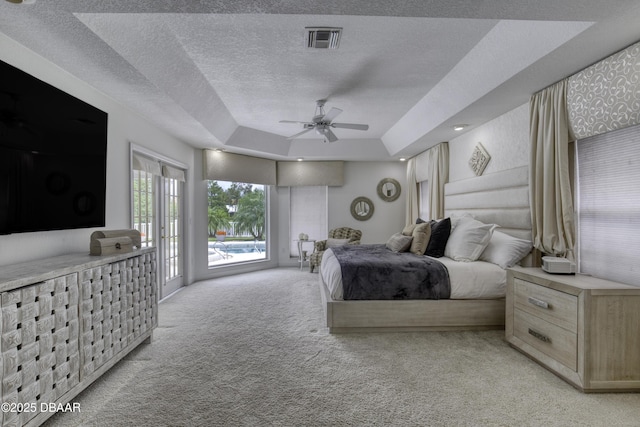 7 Foxfords Chase, Ormond Beach, FL 32174 - bedroom with light colored carpet, access to exterior, a textured ceiling, a raised ceiling, and a ceiling fan