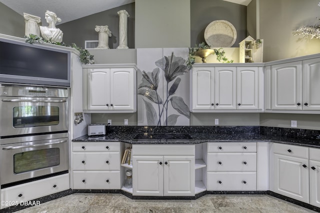 7 Foxfords Chase, Ormond Beach, FL 32174 - kitchen with stainless steel double oven, white cabinets, dark stone counters, and black electric stovetop