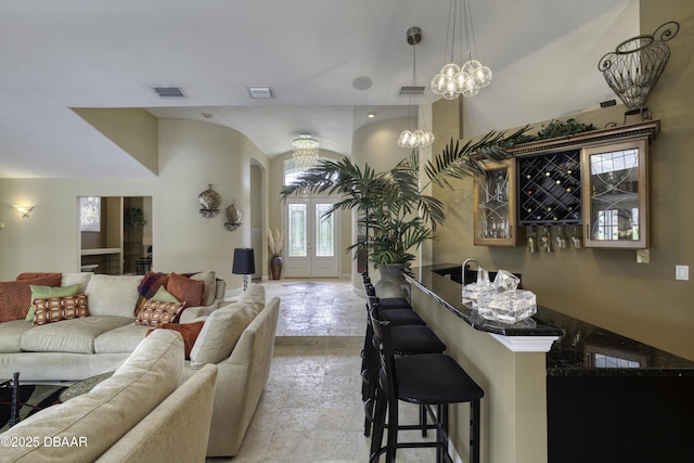 7 Foxfords Chase, Ormond Beach, FL 32174 - living room with arched walkways, wet bar, and a chandelier