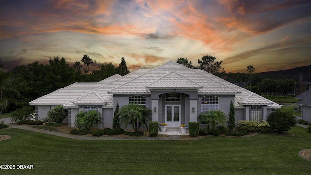 7 Foxfords Chase, Ormond Beach, FL 32174 - mediterranean / spanish-style home with a front lawn, a tile roof, stucco siding, and french doors