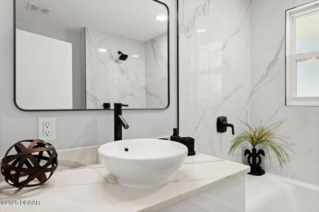 5967 Riverside Dr, Port Orange, FL 32127 - full bath featuring vanity, a textured ceiling, and a marble finish shower