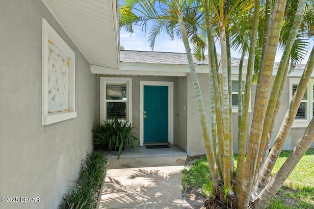5967 Riverside Dr, Port Orange, FL 32127 - doorway to property with stucco siding and roof with shingles