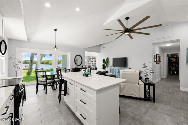 5967 Riverside Dr, Port Orange, FL 32127 - kitchen featuring ceiling fan, white cabinetry, a center island, decorative light fixtures, and a kitchen breakfast bar