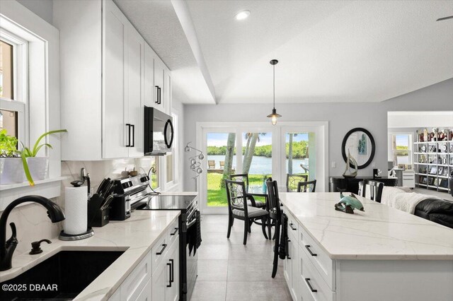 5967 Riverside Dr, Port Orange, FL 32127 - kitchen featuring black microwave, stainless steel electric stove, light stone counters, white cabinetry, and decorative light fixtures