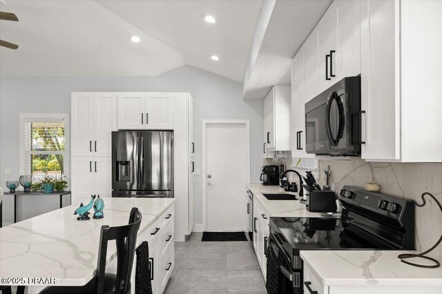 5967 Riverside Dr, Port Orange, FL 32127 - kitchen featuring black appliances, backsplash, white cabinets, lofted ceiling, and recessed lighting