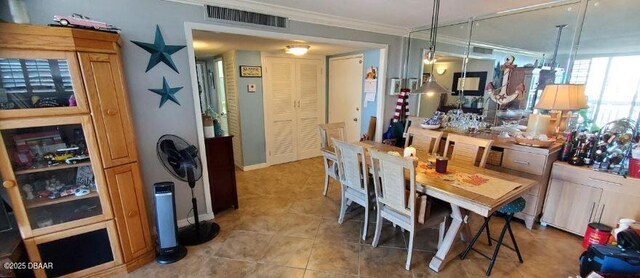 tiled dining space with ornamental molding and visible vents