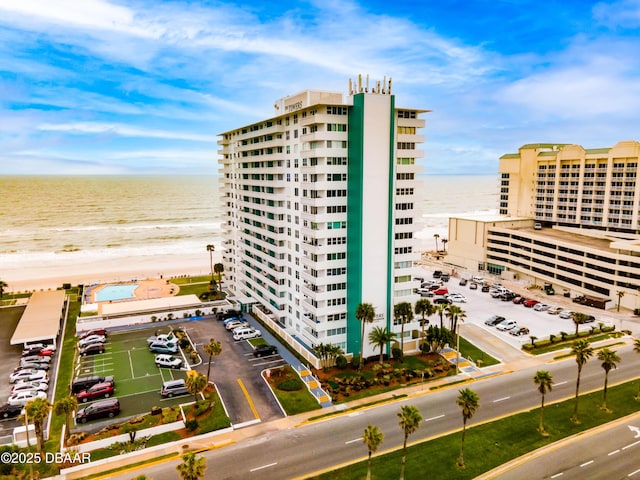 view of building exterior featuring a water view and a view of the beach