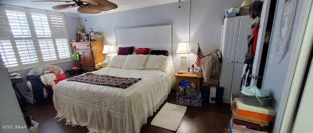 bedroom with wood finished floors, crown molding, and ceiling fan