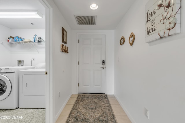 laundry area with light tile patterned flooring, laundry area, separate washer and dryer, visible vents, and baseboards