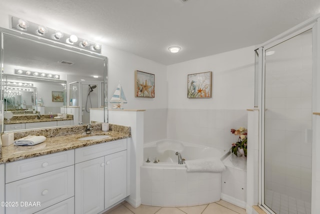 full bathroom with a stall shower, tile patterned flooring, vanity, and a bath