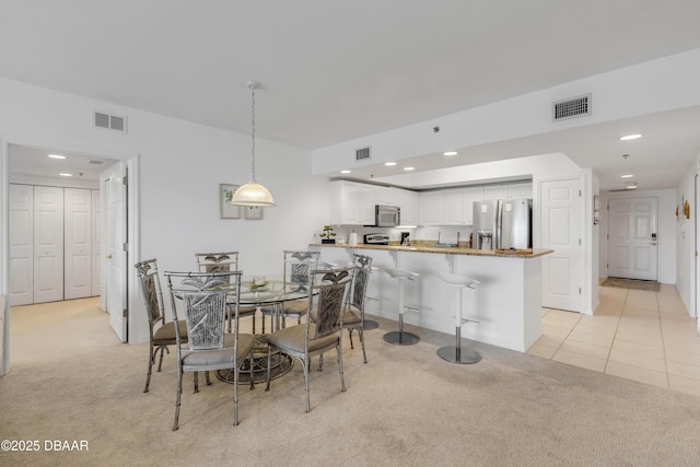 dining space featuring light carpet and visible vents