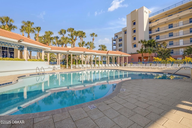 community pool featuring a patio and fence