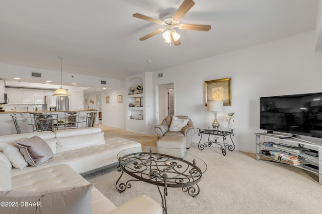 living room with light carpet, ceiling fan, and visible vents