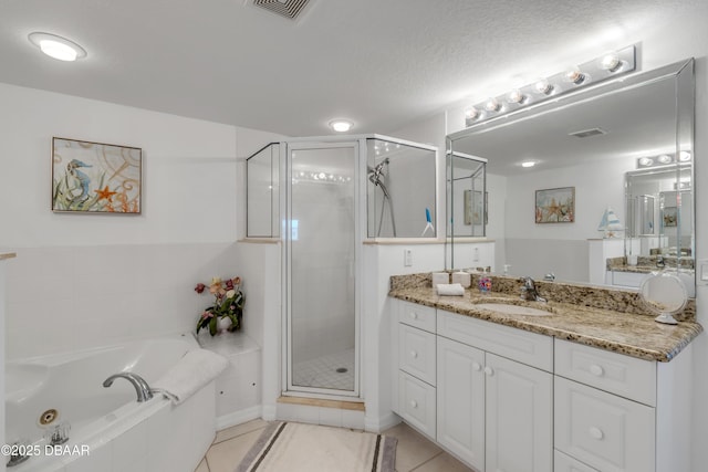 bathroom with a textured ceiling, tile patterned flooring, a shower stall, and visible vents