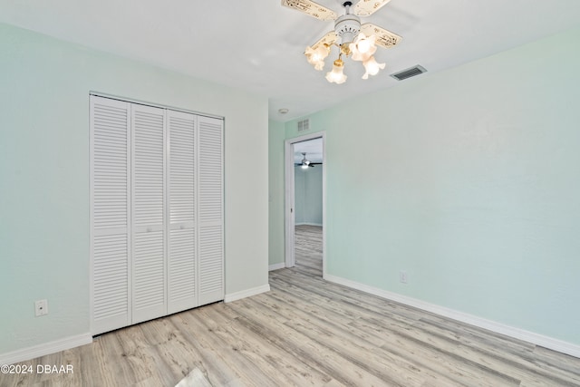 unfurnished bedroom featuring light hardwood / wood-style flooring, ceiling fan, and a closet