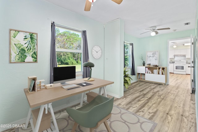 home office featuring ceiling fan and light hardwood / wood-style flooring