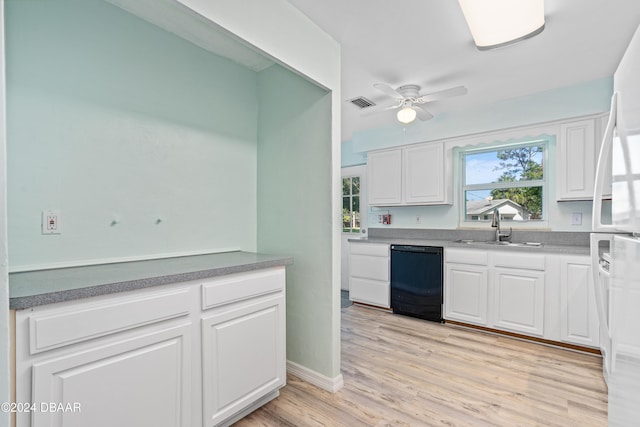 kitchen featuring sink, ceiling fan, white cabinets, light wood-type flooring, and black dishwasher