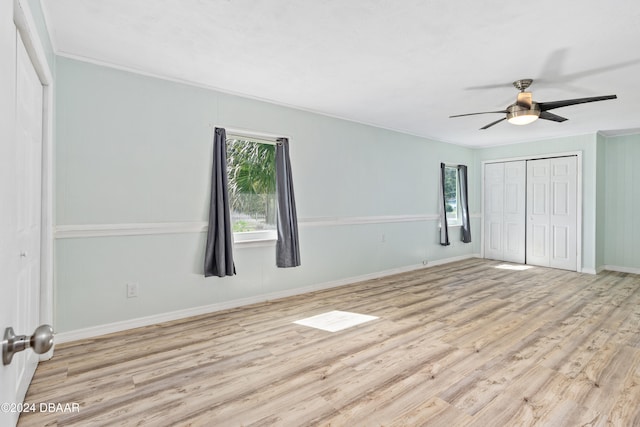 unfurnished bedroom featuring crown molding, ceiling fan, light hardwood / wood-style floors, and a closet