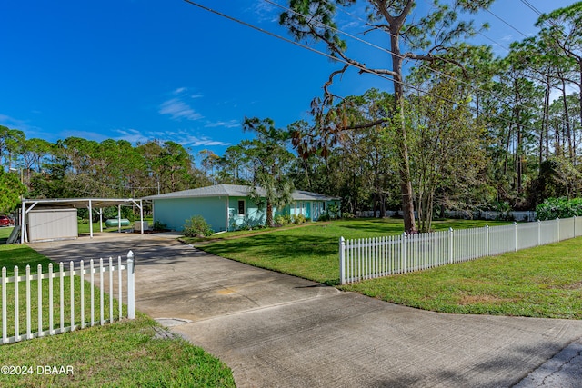 ranch-style home with a shed, a front lawn, and a carport