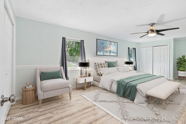 bedroom with crown molding, light hardwood / wood-style floors, a closet, and ceiling fan