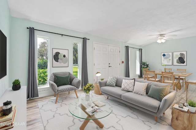 living room featuring vaulted ceiling, light hardwood / wood-style floors, and ceiling fan