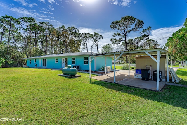 605 Orchard Ave, Ormond Beach, FL 32174 - rear view of house featuring a lawn, a carport, and a patio