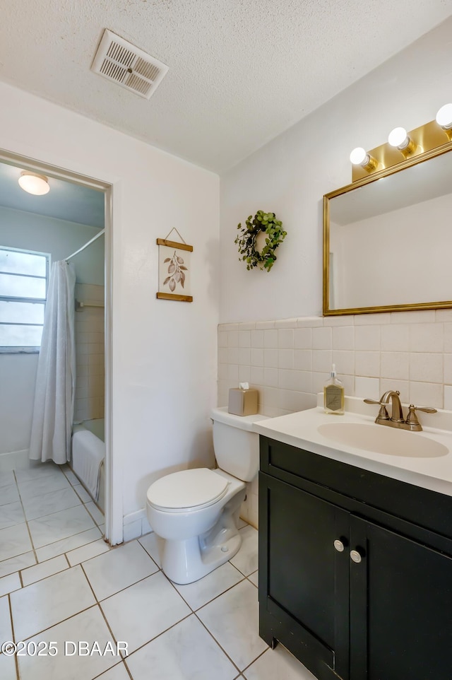 full bathroom featuring tile patterned floors, toilet, shower / tub combo, a textured ceiling, and vanity